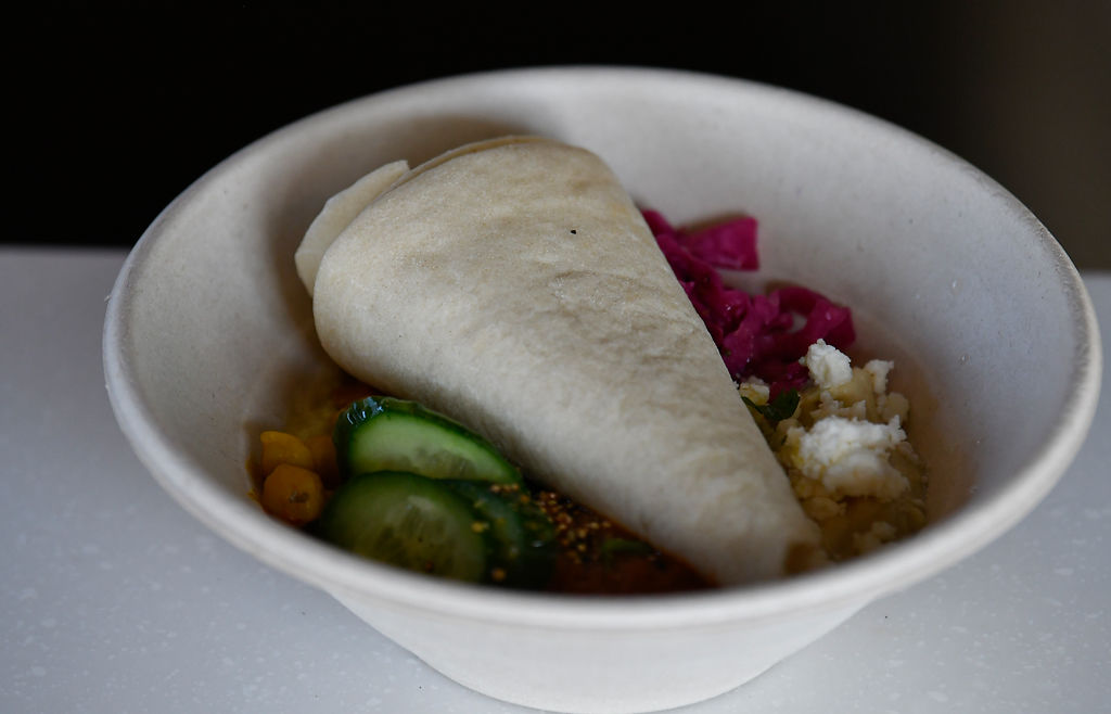 A dish features beets, cucumber and flatbread